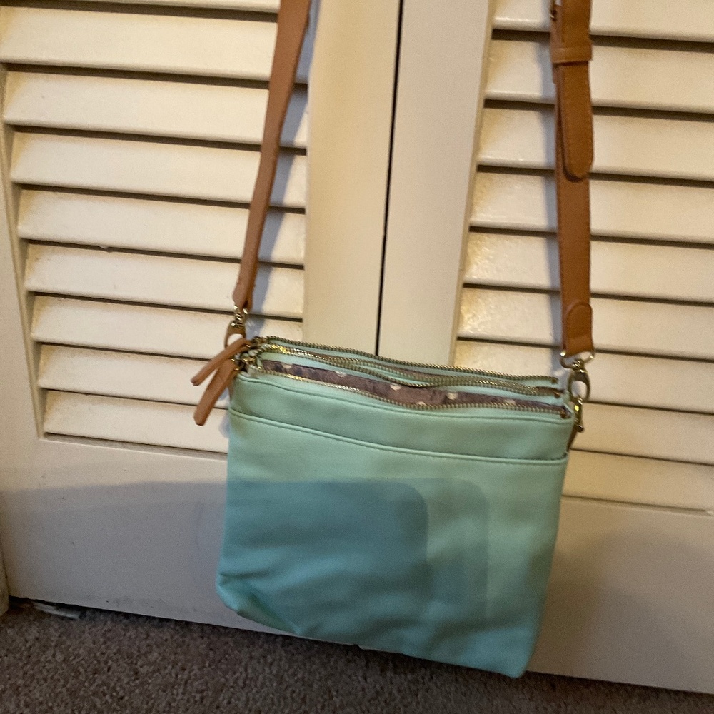 Mint green and tan cross body purse with grey and white polka dot fabric inside